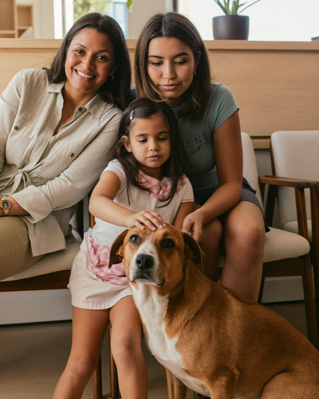 Una familia con su perro criollo esperando en la sala de una veterinaria